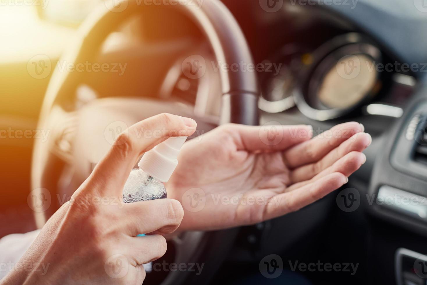 Händedesinfektion des Fahrers mit antibakteriellem Desinfektionsmittel im Auto vor dem Fahren foto