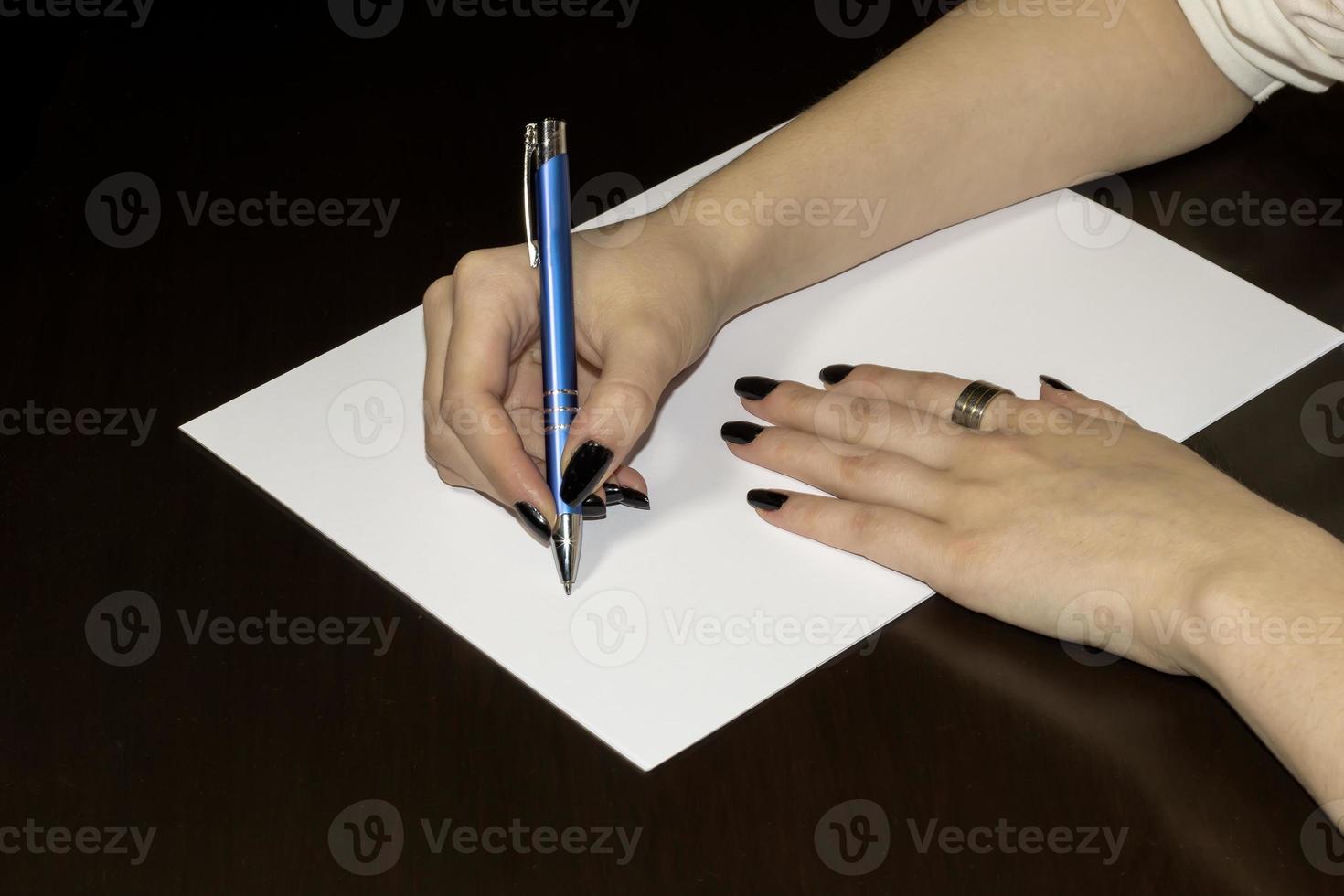 Frauenhände schreiben auf weißem Papier. klar leer foto