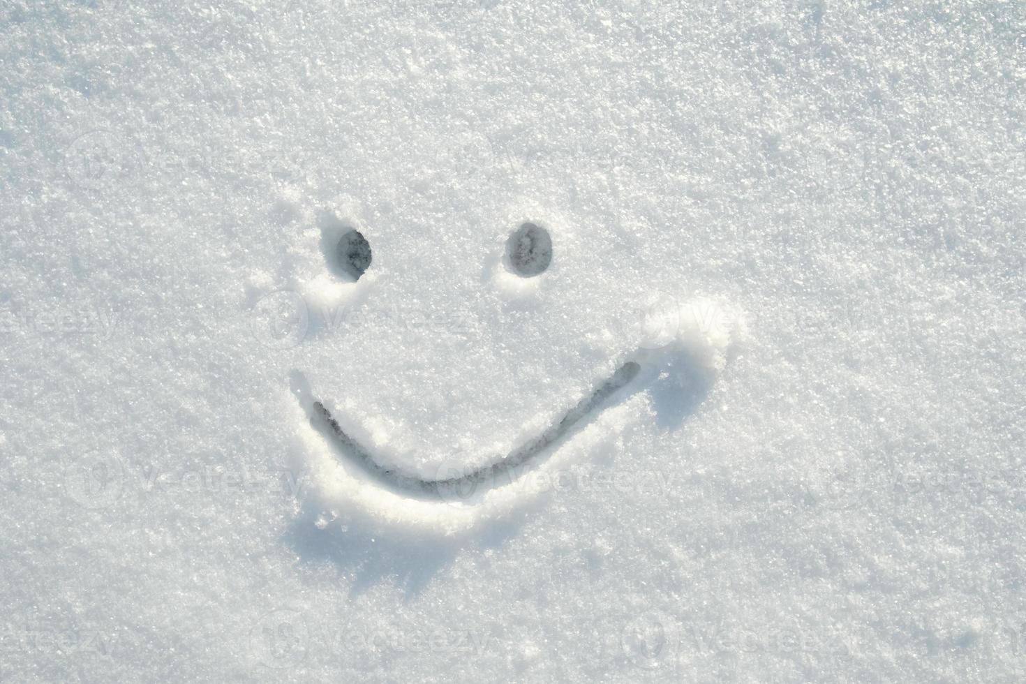 Gesicht zufrieden, süßes Smiley-Gesicht an einem sonnigen Wintertag in den Schnee gezeichnet. Platz kopieren. foto