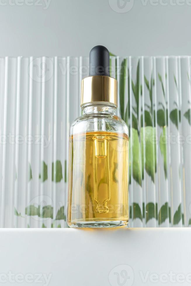 Kosmetikflasche aus Glas mit Pipette auf weißem Podium, Produktverpackung, Anti-Aging-Serum mit Peptiden, Kosmetikmodell, Spa-Konzept. foto