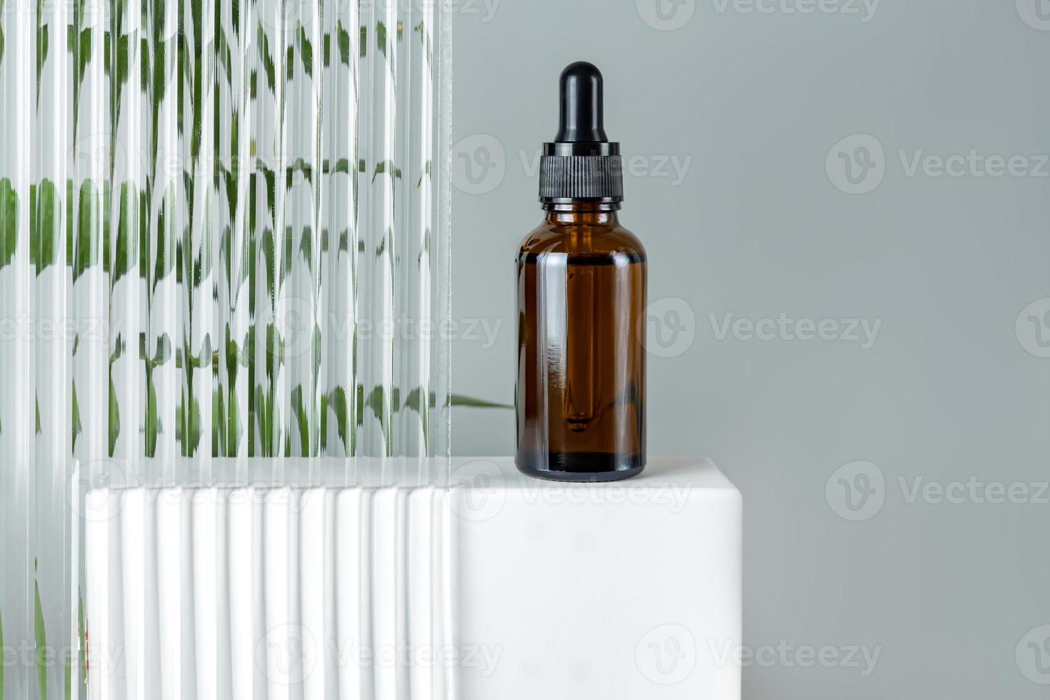 Beauty-Gesichtsöl in Braunglas-Tropfflasche auf einem Podium. trendiges Shooting von Kosmetikverpackungen. ätherisches Öl mit natürlichen Inhaltsstoffen. Tierversuchsfreie Kosmetik foto