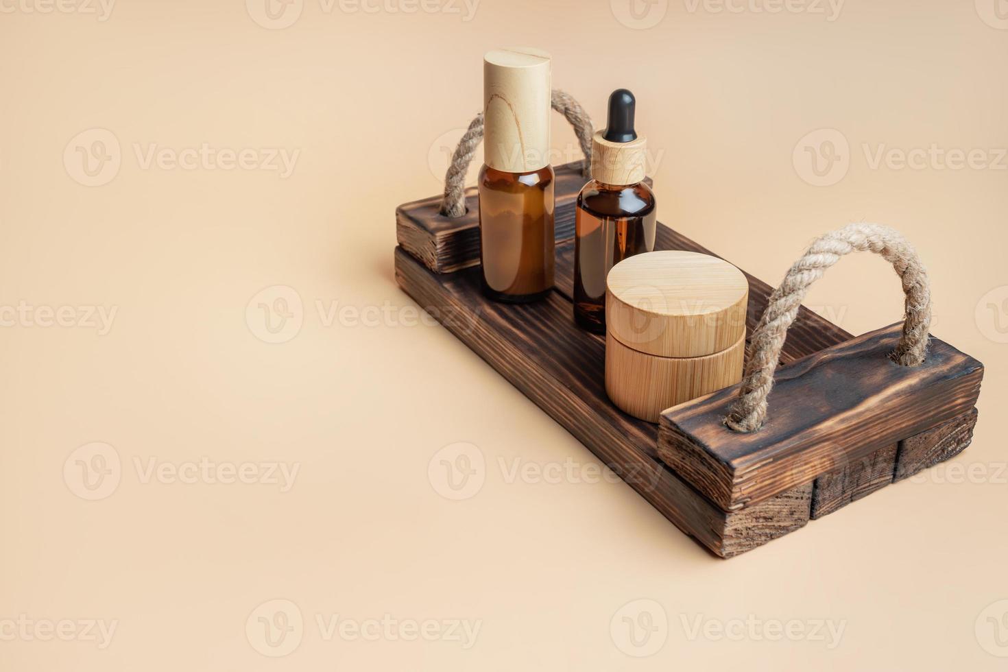 Naturkosmetik in Bambus- und Glasverpackung auf Holztablett auf beigem Hintergrund mit Platz für Text. spa organische schönheitsprodukte gesetzt. Hautpflegekonzept. foto