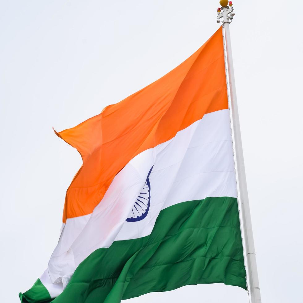 Indien-Flagge, die hoch am Connaught-Platz mit Stolz auf den blauen Himmel fliegt, Indien-Flagge flattert, indische Flagge am Unabhängigkeitstag und Tag der Republik Indien, Schuss nach oben geneigt, indische Flagge schwenkend, Har Ghar Tiranga foto