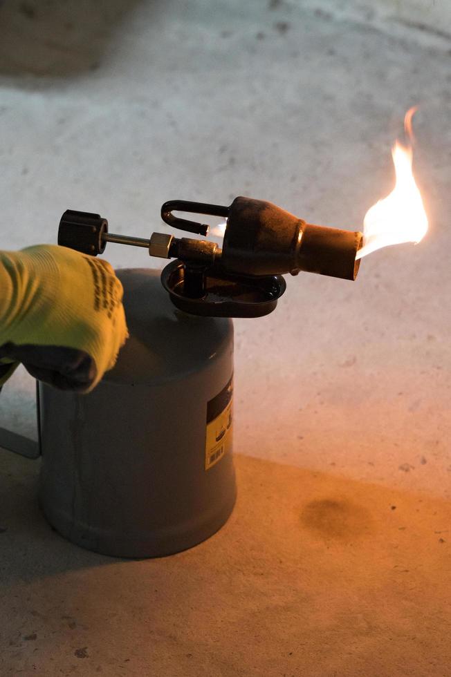 Benzinbrenner mit brennendem Feuer, Verwendung einer Lötlampe im Bauwesen. foto