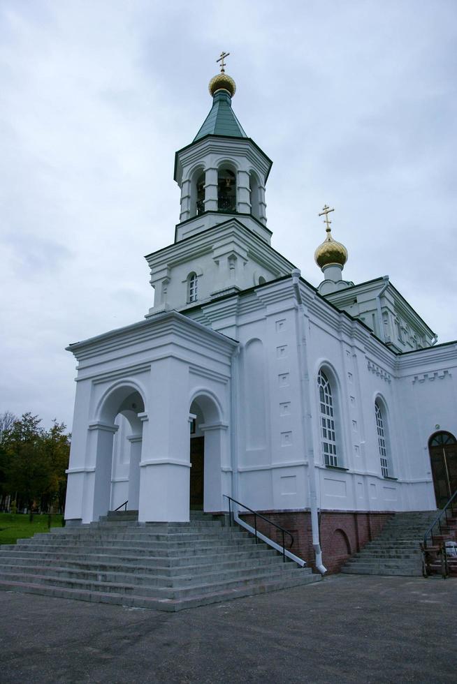 eine große weiße steinkirche mit einer goldenen kuppel und einer glocke in osteuropa ist eine christlich-orthodoxe für die gebete gottes foto