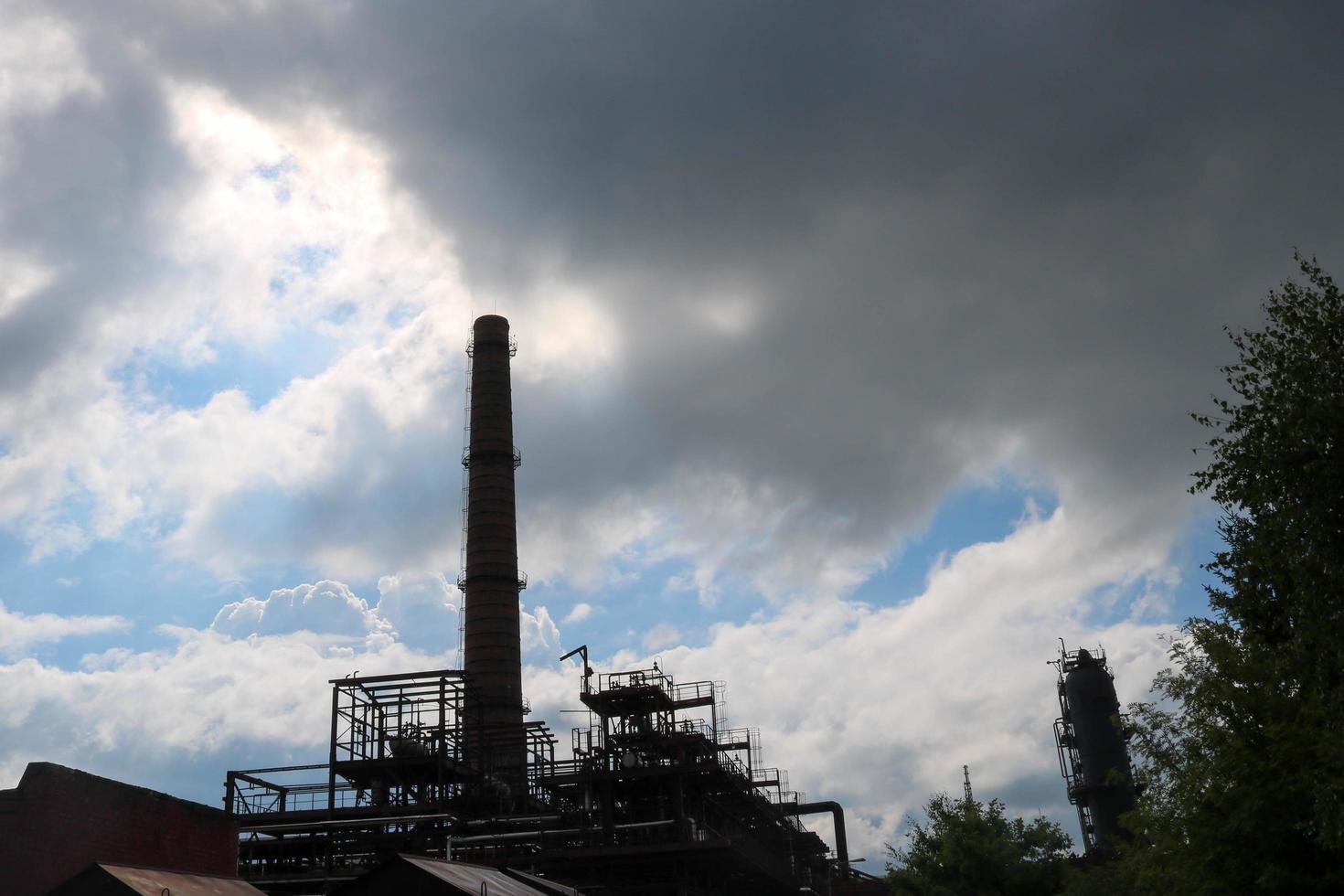 Ein großes, hohes, nicht-ökologisches metallisches Eisenrohr für die Emission von Rauchgas in der industriellen Raffinerie der petrochemischen chemischen Raffinerie vor dem Hintergrund des blauen Himmels foto