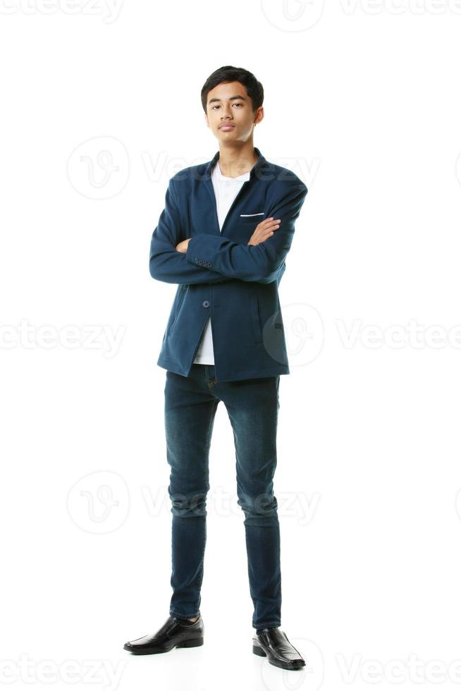 ein Ganzkörperporträt eines frühen Teenagers. smarter, schlanker, großer asiatischer mann in lässiger kleidung, der elegant auf weißem hintergrund steht. foto