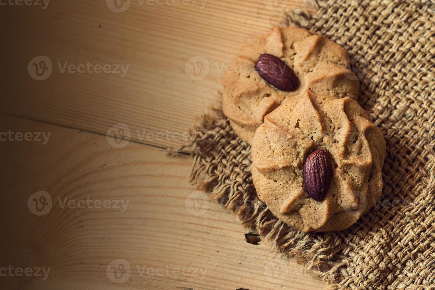 Mandelplätzchen mit Mandelnüssen auf Holztischhintergrund mit Platz für Text foto