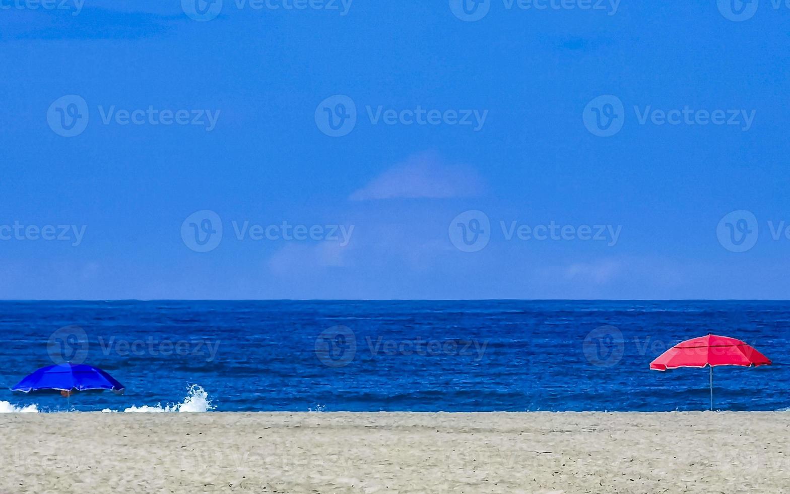 sonnenschein sonnenschirm wellen und strand sand puerto escondido mexiko. foto