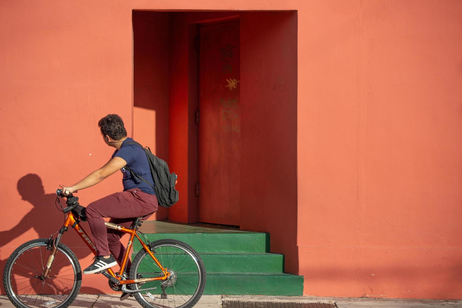 Miami, Florida, 2020 - Mann, der Fahrrad vor buntem Gebäude fährt foto