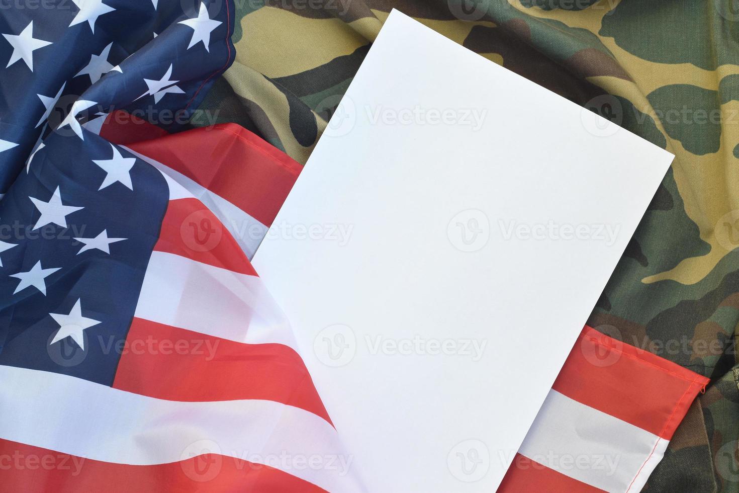 leeres papier liegt auf der flagge der vereinigten staaten von amerika und der gefalteten militäruniformjacke. konzeptionelle hintergrundfahne der militärischen symbole und kopierraum foto