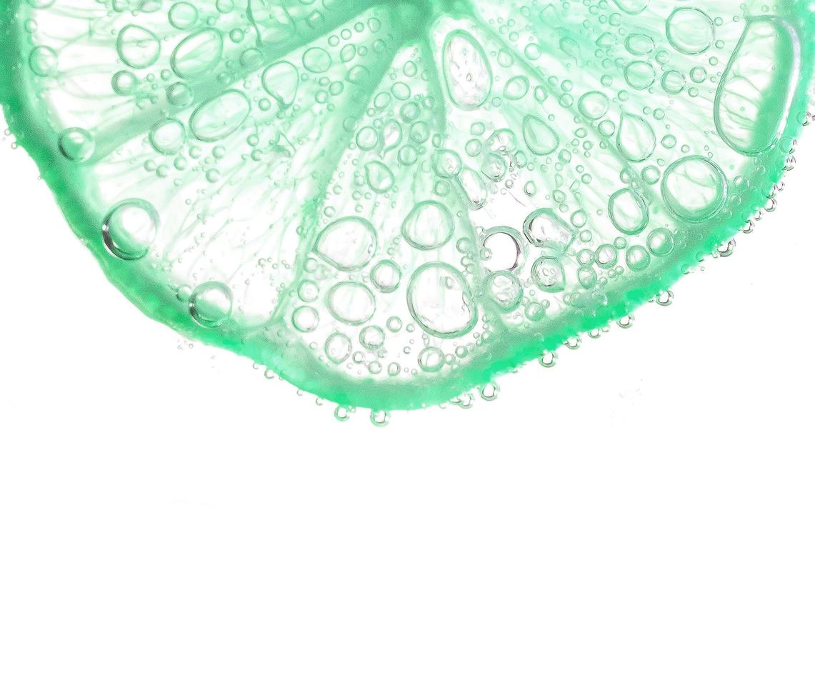 saftige Limettenscheiben mit Blasen unter Wasser isoliert auf weißem Hintergrund. grüner zitronenscheibenmuster strukturierter hintergrund. foto
