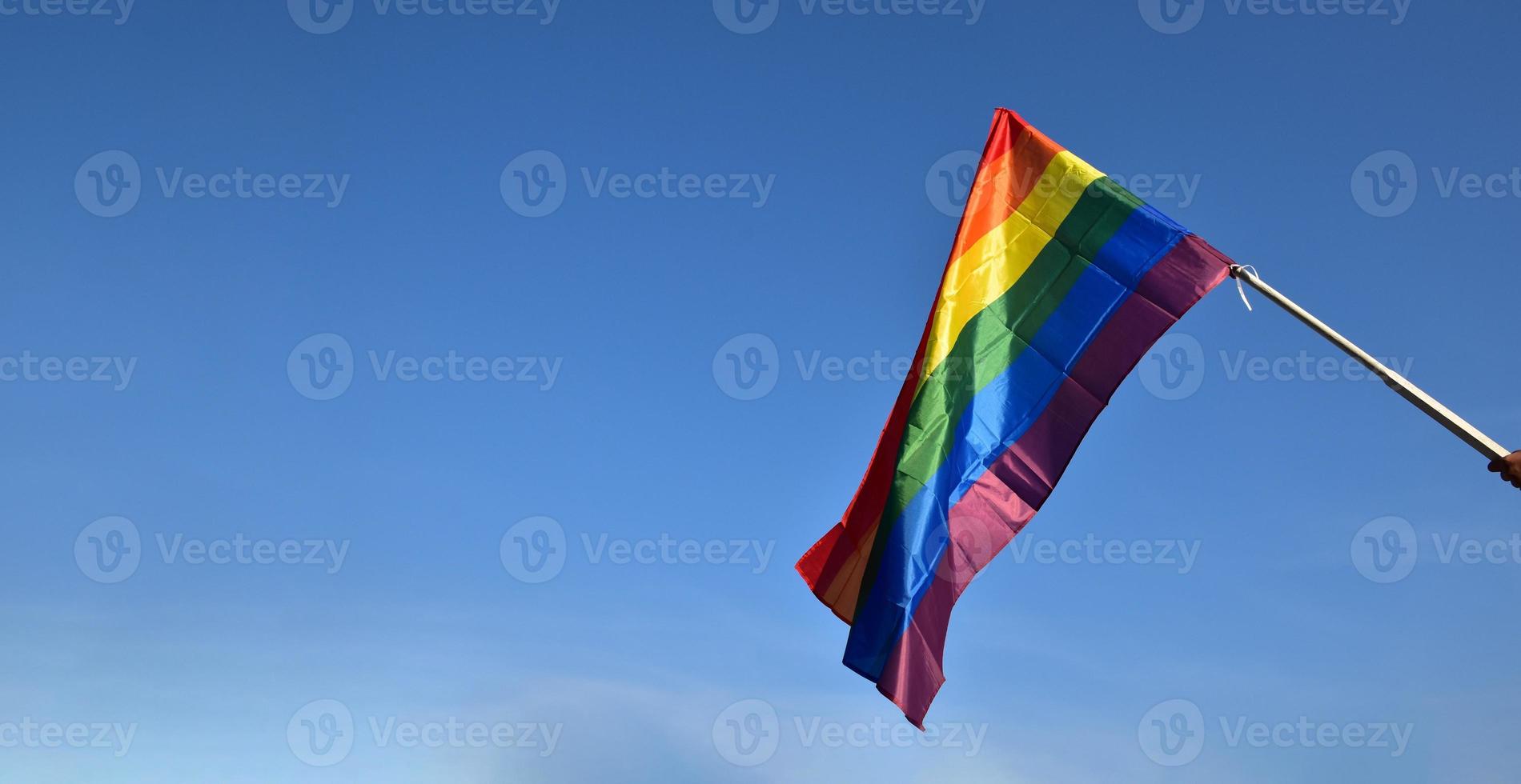 Blick nach oben auf die Regenbogenfahne, lgbt-Simbol, vor klarem blauem Himmel, weicher und selektiver Fokus, Konzept für die lgbt-Feier im Stolzmonat, Juni, auf der ganzen Welt, Kopierraum. foto