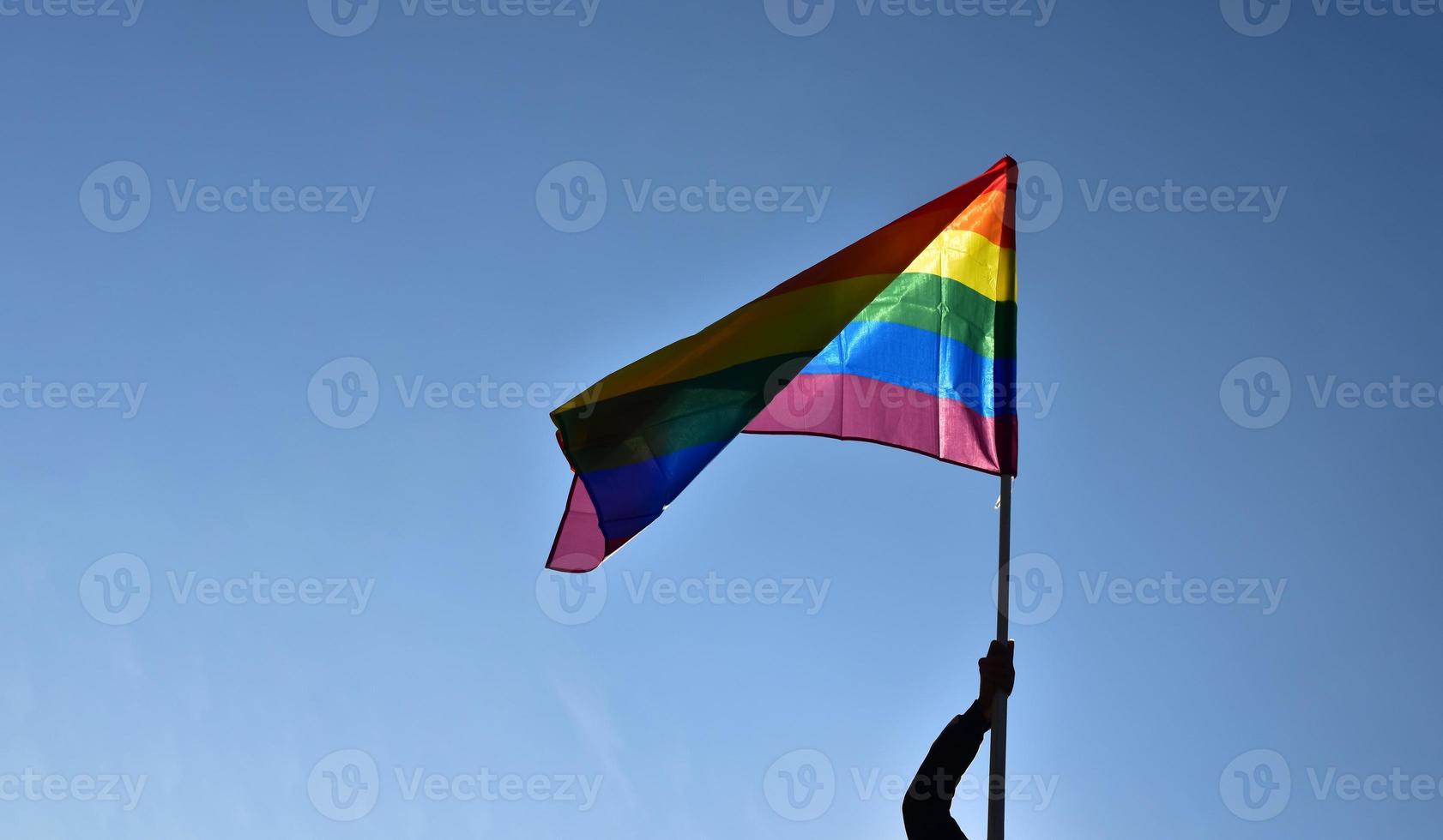 Blick nach oben auf die Regenbogenfahne, lgbt-Simbol, vor klarem blauem Himmel, weicher und selektiver Fokus, Konzept für die lgbt-Feier im Stolzmonat, Juni, auf der ganzen Welt, Kopierraum. foto