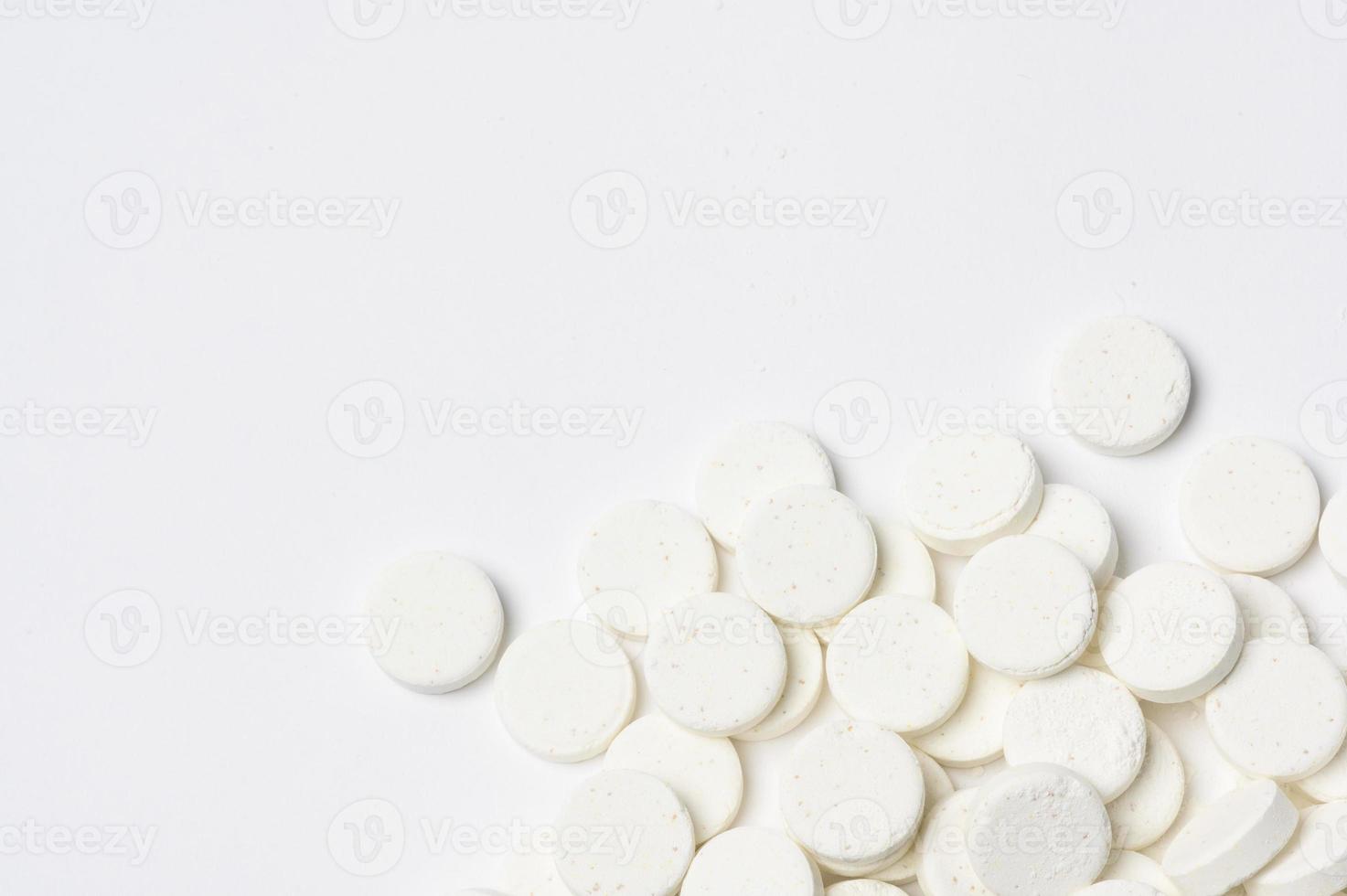weiße Medizinpillen der Nahaufnahme auf weißem Hintergrund foto