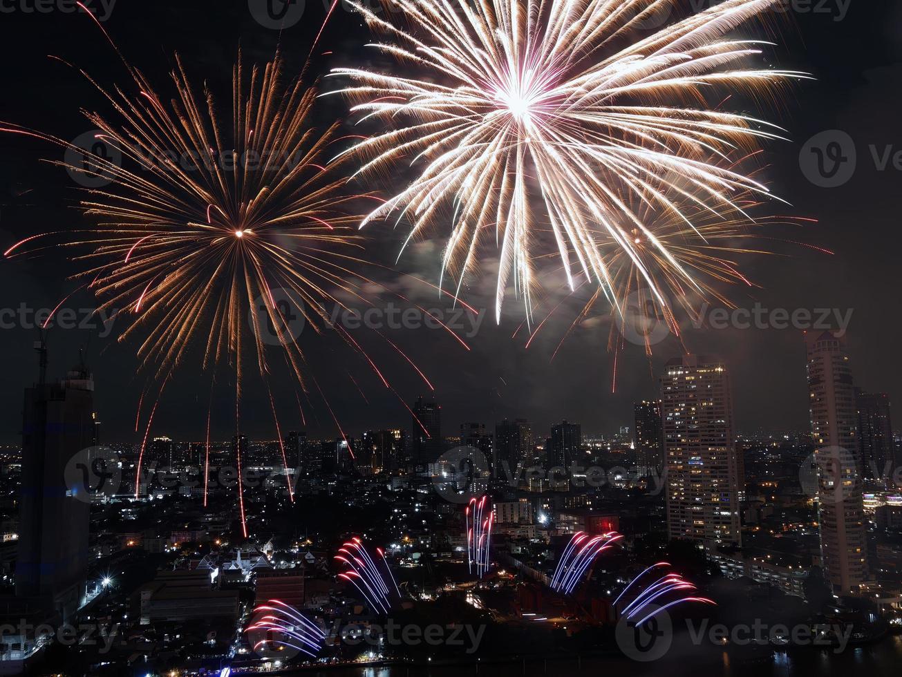 hochwinkelansicht fantastische mehrfarbige langzeitbelichtungsaufnahme von feuerwerk über dem chao phraya fluss, stadtbild von bangkok, festival, feier, frohes neues jahr, geschäftsarchitektur. foto