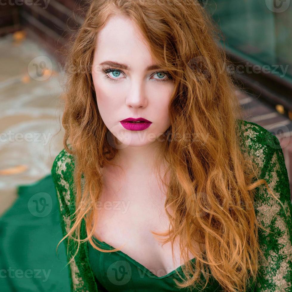 Redhead schönes junges Mädchen im langen grünen Kleid foto
