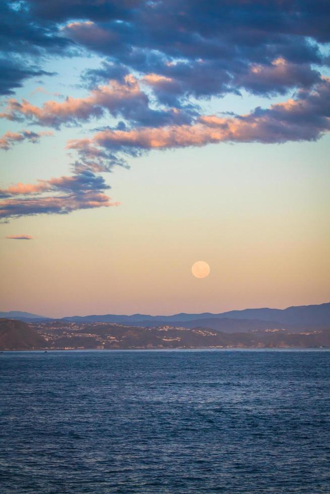 Mond über dem Ozean bei Sonnenuntergang foto