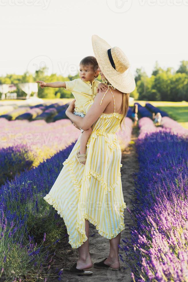 schöne Frau und ihr süßer kleiner Sohn im Lavendelfeld foto