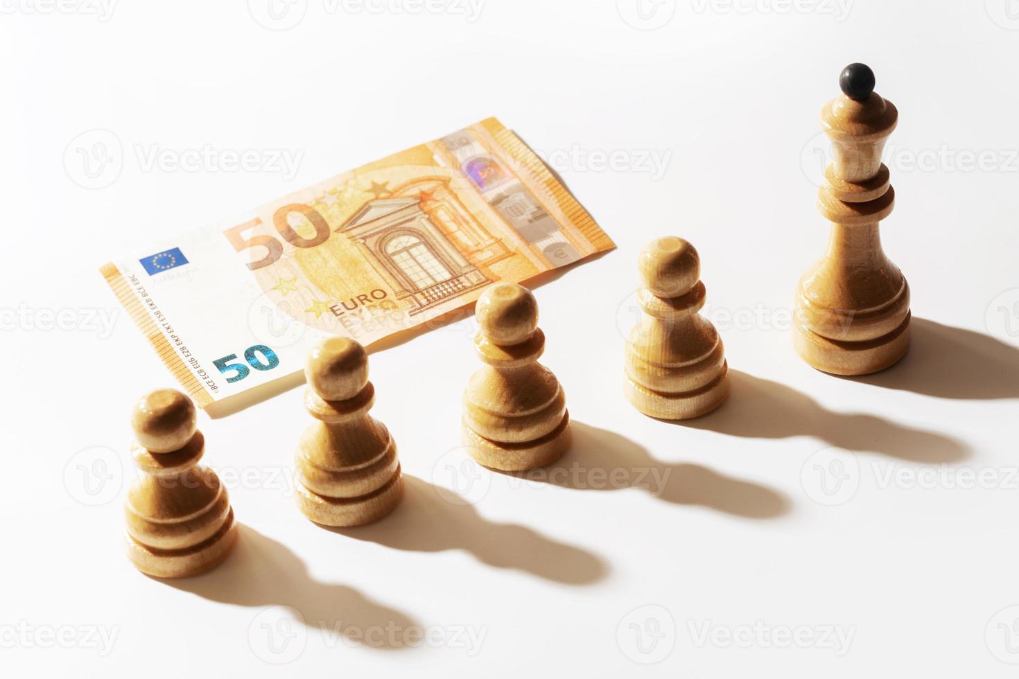 50-Euro-Banknote und eine Reihe hölzerner Schachfiguren. foto