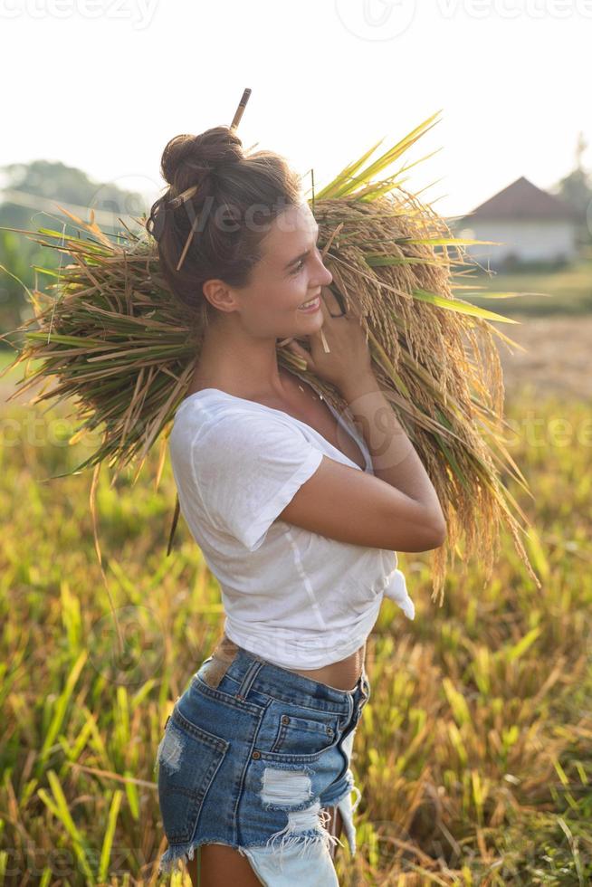 glückliche Bäuerin während der Ernte auf dem Reisfeld foto