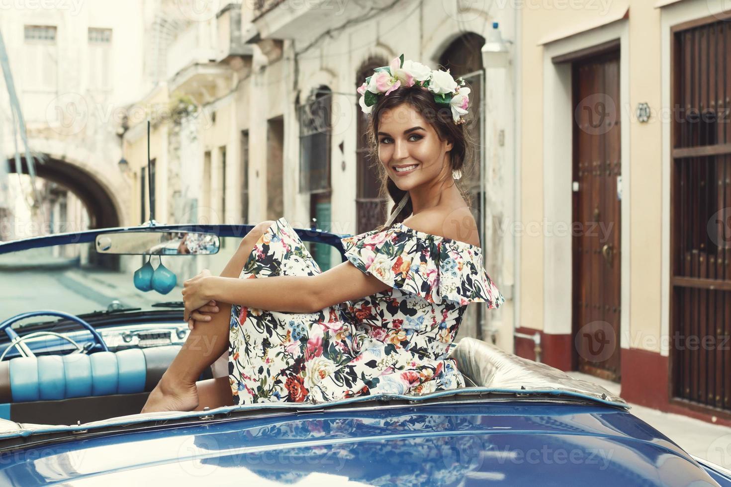 frau, die schönes kleid und retro-cabrio-auto trägt foto