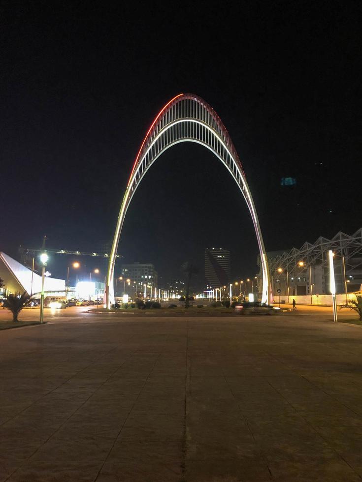 ein großer schöner metallischer moderner leuchtender moderner bogen des schwarzen meeres ist nachts der eingang zum botanischen garten von batumi. Batumi, Georgien, 17. April 2019 foto