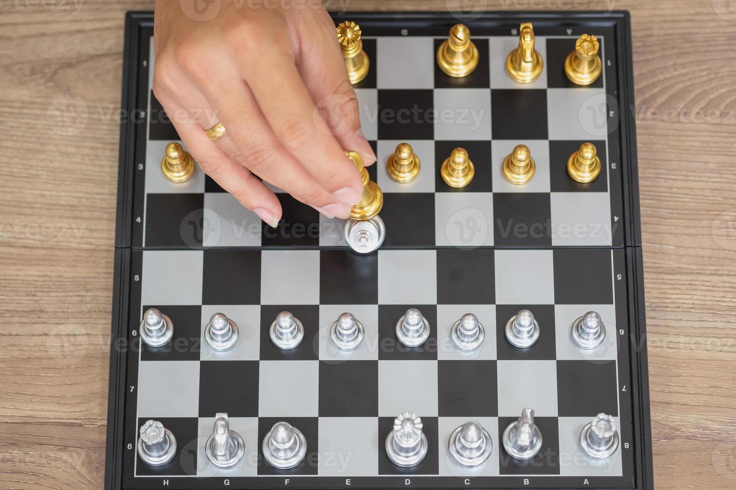 Das Unternehmen ist ein Geschäftsmann, dessen Hände Schach auf dem Spielplan bewegen, um das Geschäft auf dem Markt zu gewinnen. Konzept der Führung foto