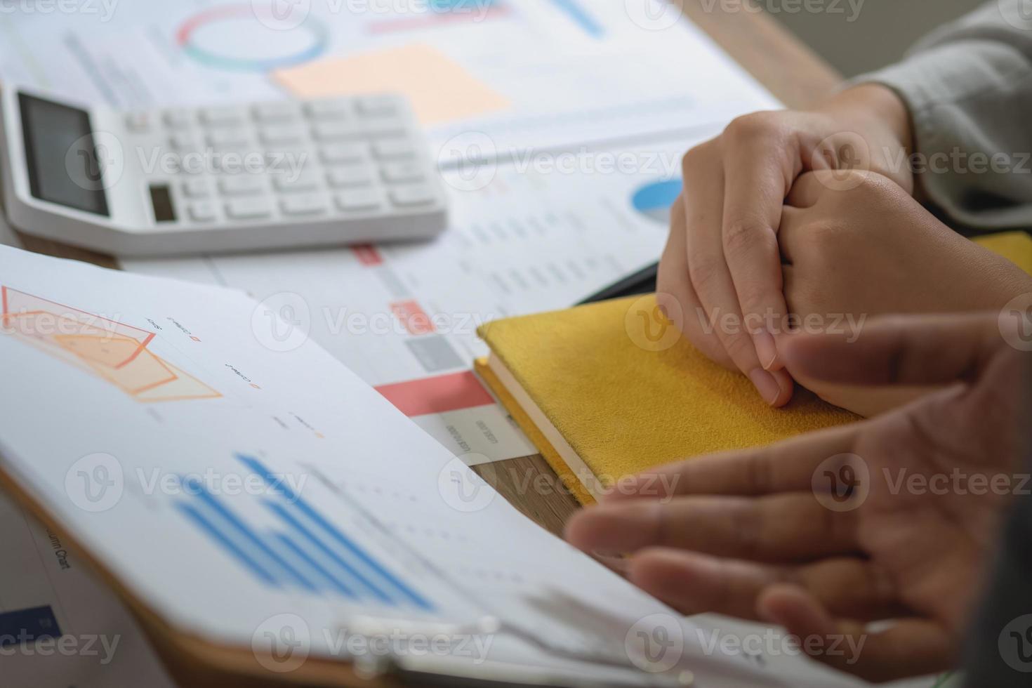 Marketing, Finanzen, Buchhaltung, Planung, ein Team von Geschäftsleuten plant mit ihren Laptops und Diagrammen ihre Gewinne und berechnet mit einem Taschenrechner die Jahresbilanz ihres Unternehmens. foto