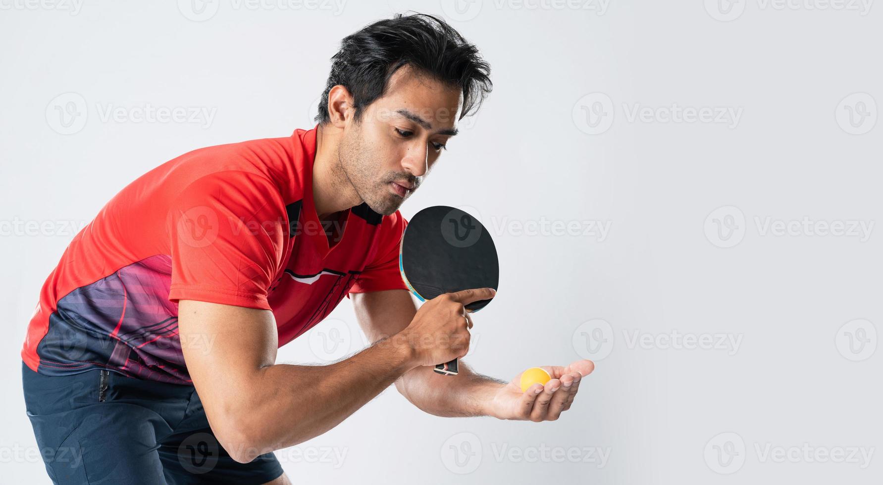 Porträt des männlichen Athleten des Sportlers, der Tischtennis spielt, isoliert. foto
