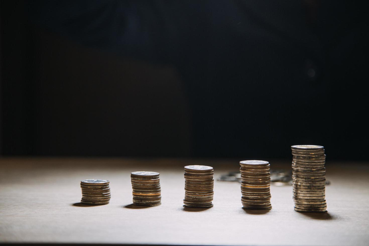 geschäftsbuchhaltung mit geldsparen mit der hand, die münzen in das krugglaskonzept einlegt finanziell foto