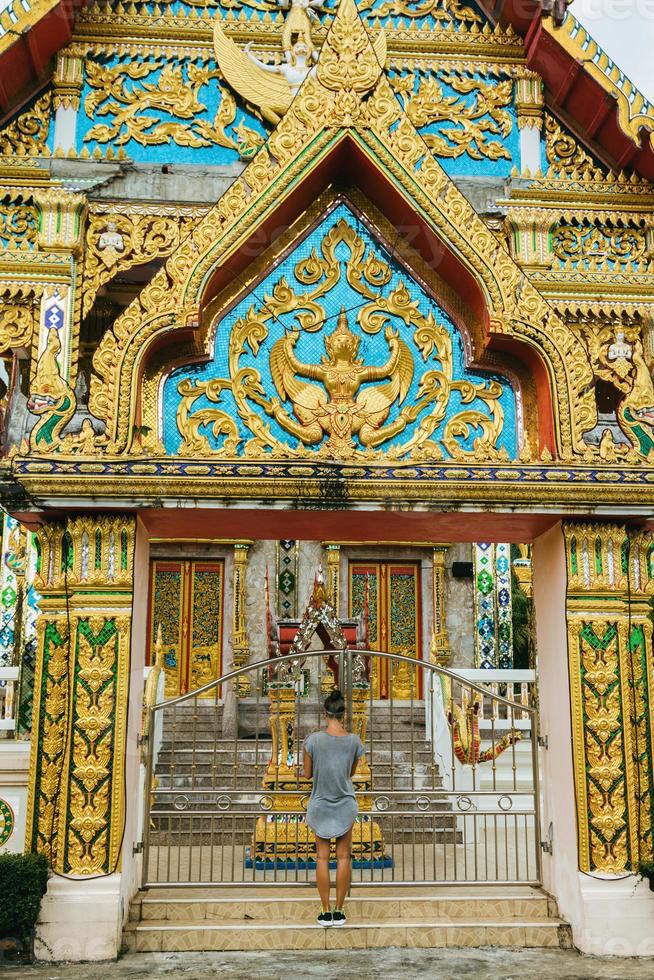 junge weibliche touristin besichtigt buddhistischen tempel in thailand. foto