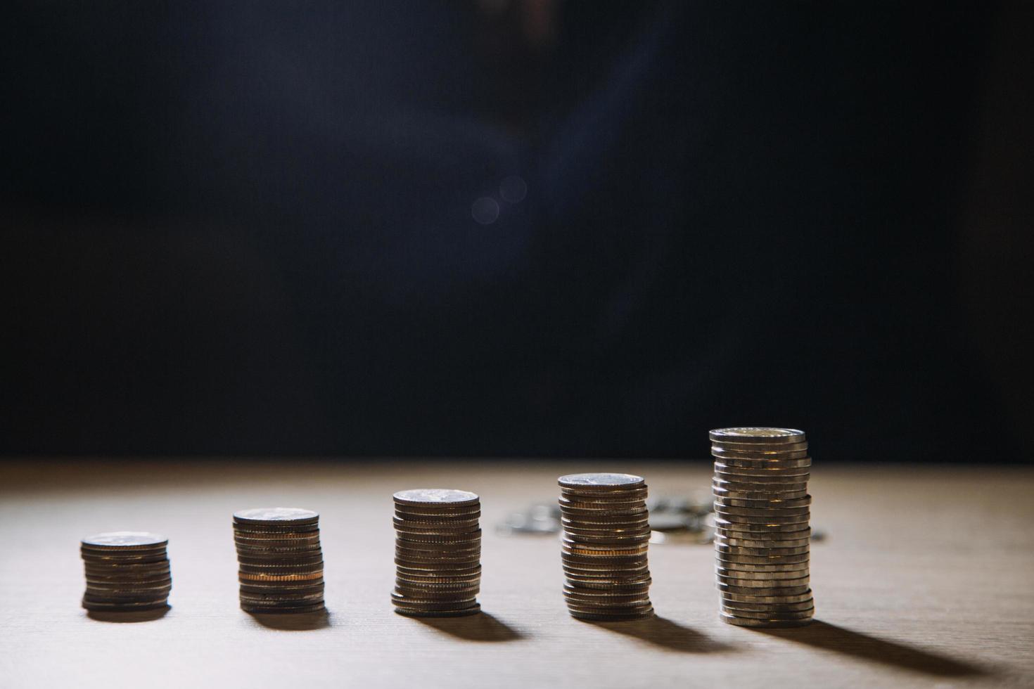 Hand, die Münzgeld auf Stapelmünze legt. Konzept investieren. foto