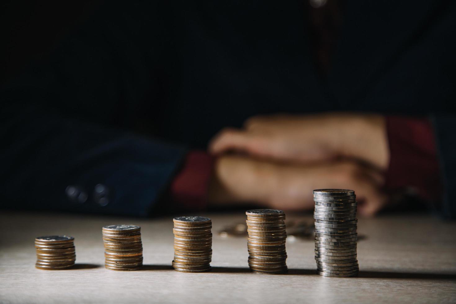 geschäftsfrau hand berechnet ihr geld am ende des monats mit münze, rechner und kalender auf holztisch foto