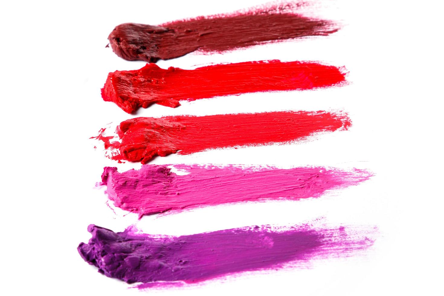 Verschiedene mehrfarbige Proben eines verschmierten Lippenstifts foto