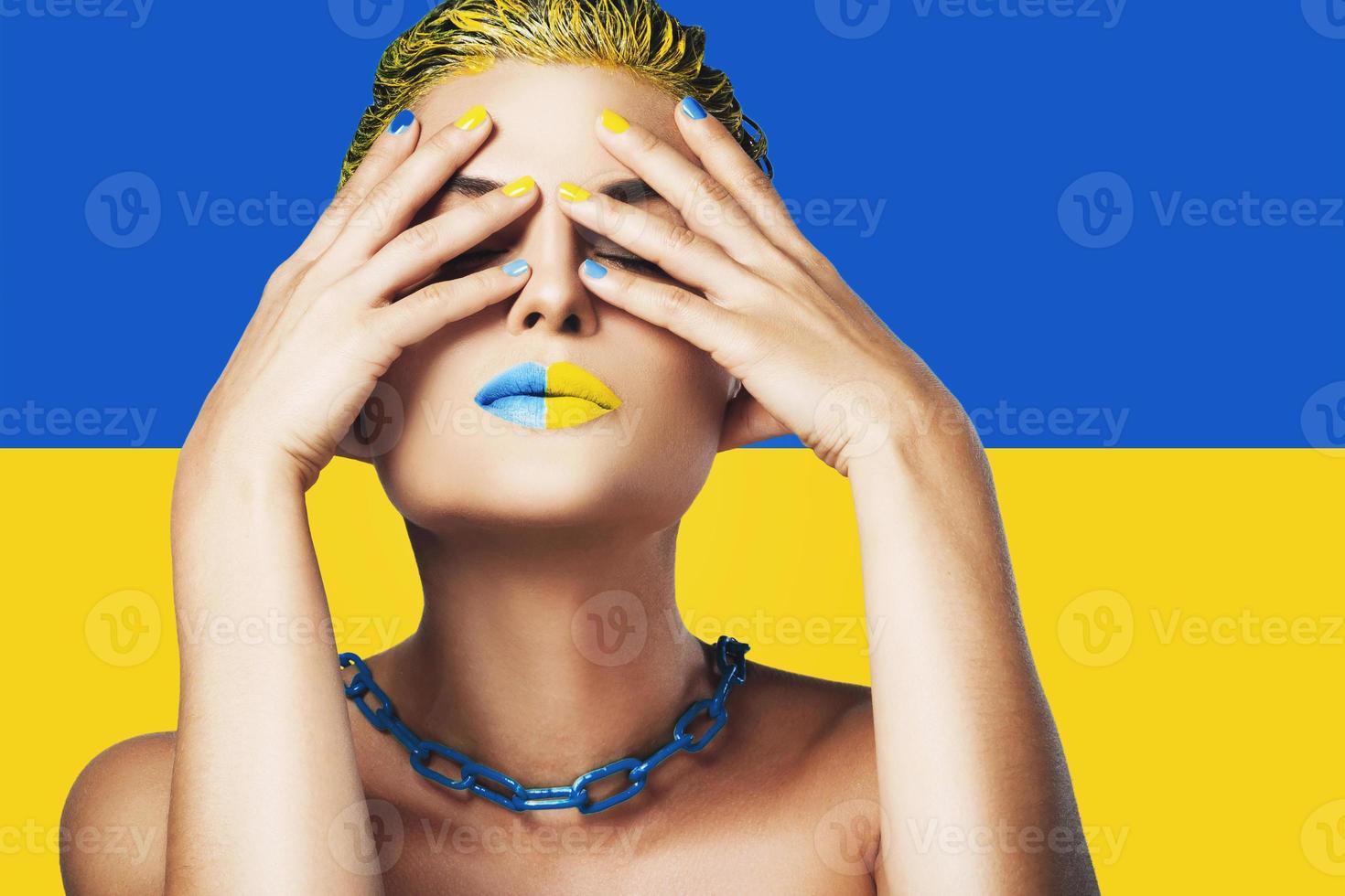 Umgekippte Frau mit gelb-blauem Lippenstift und ukrainischer Flagge im Hintergrund foto