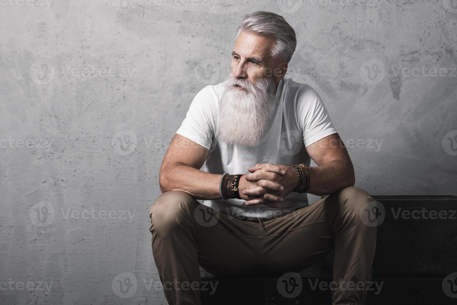 hübscher bärtiger älterer mann, der im studio aufwirft foto