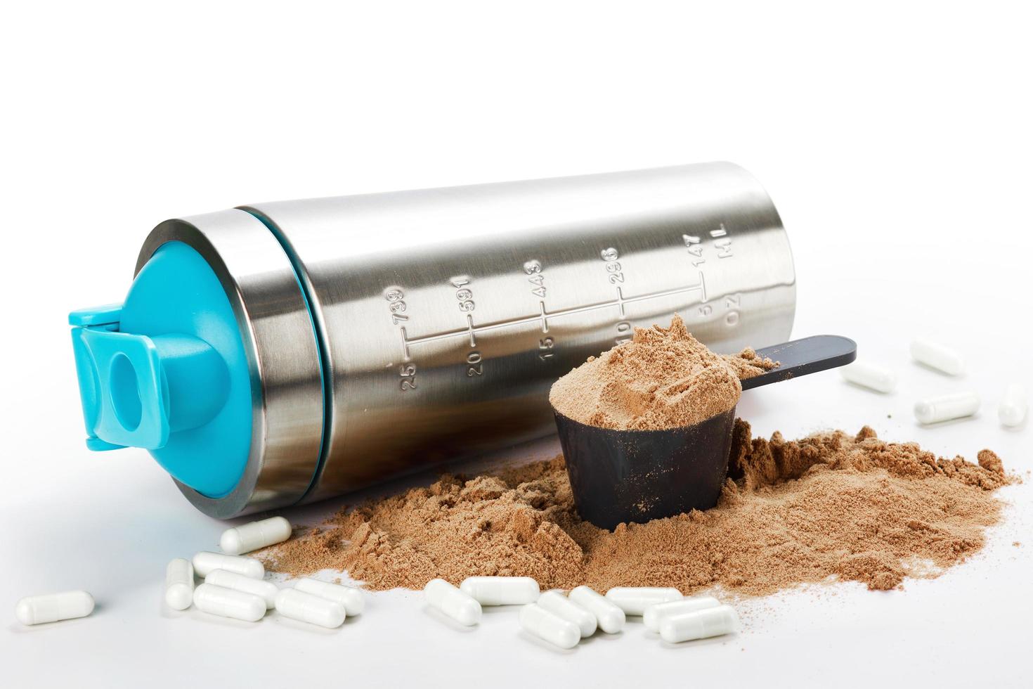 Shaker, Schaufel mit Proteinpulver und Pillen foto