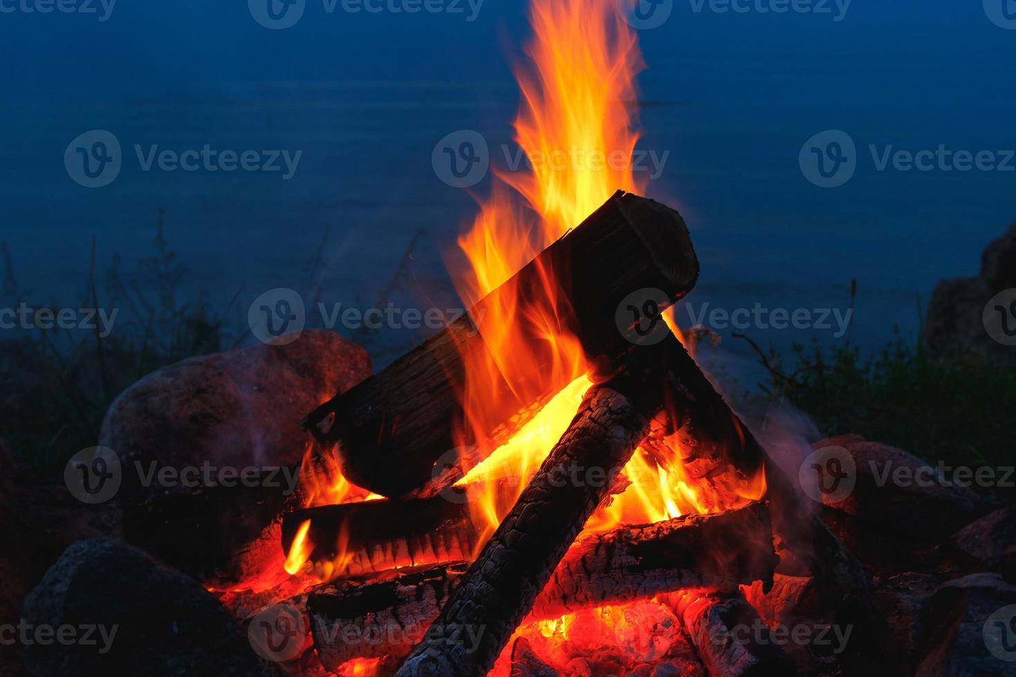 Nahaufnahme eines Lagerfeuers im Freien, das nachts hell brennt. foto