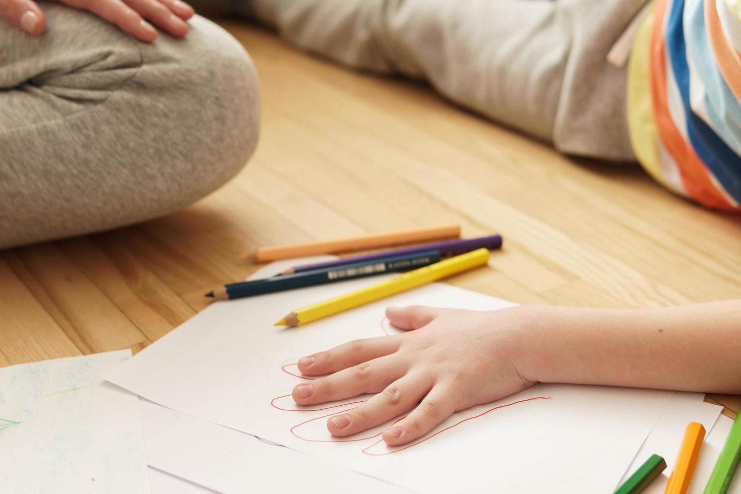 Mutter zeichnet Umrisse der Handfläche ihres Sohnes foto