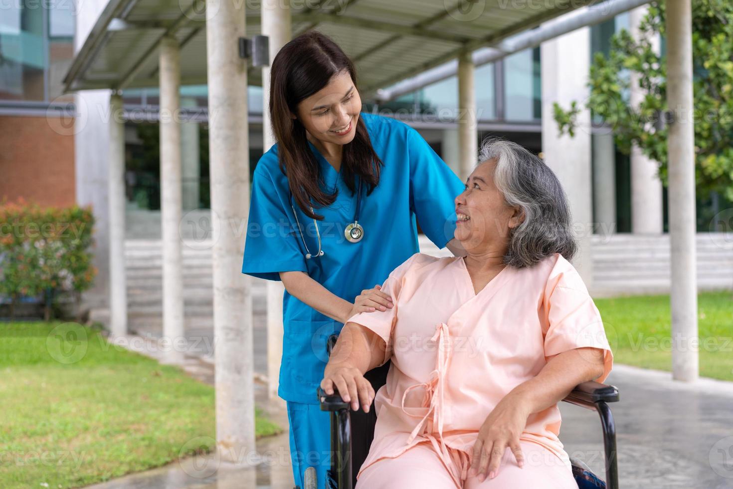 asiatische Pflegekraft oder Krankenschwester, die sich um den Patienten im Rollstuhl kümmert. Konzept des glücklichen Ruhestands mit Betreuung durch eine Pflegekraft und Spar- und Seniorenkrankenversicherung, eine glückliche Familie foto