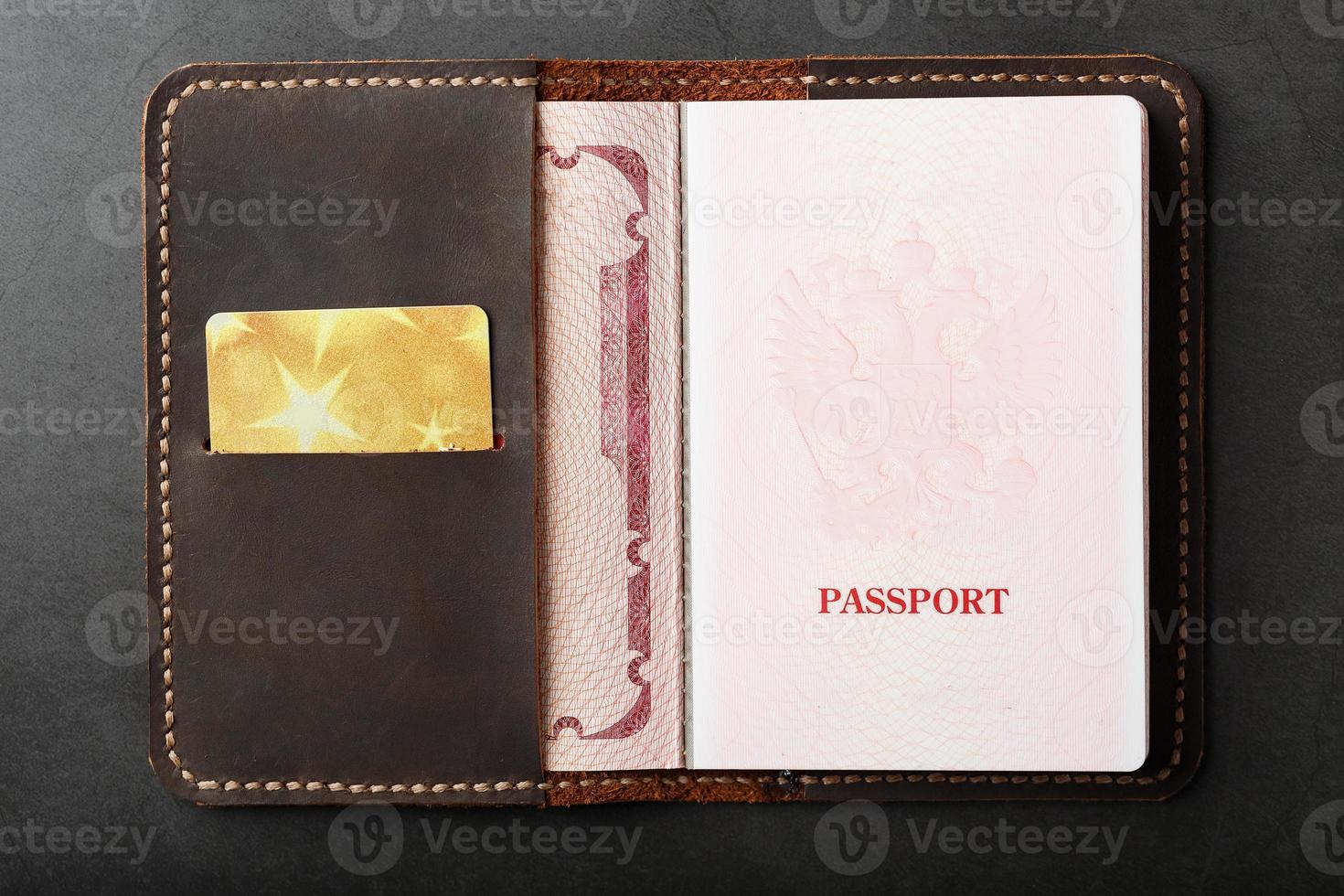 Öffnen Sie die Passlederhülle mit goldener Kreditkarte foto