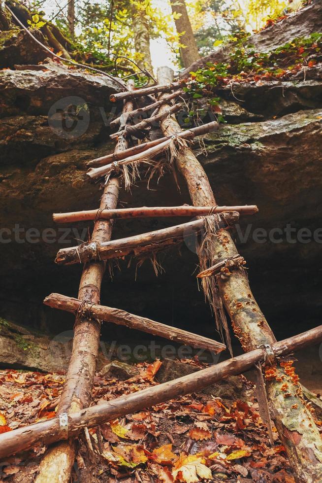 eine alte Treppe, die zum Wasserfall im herbstlichen Wald führt. foto