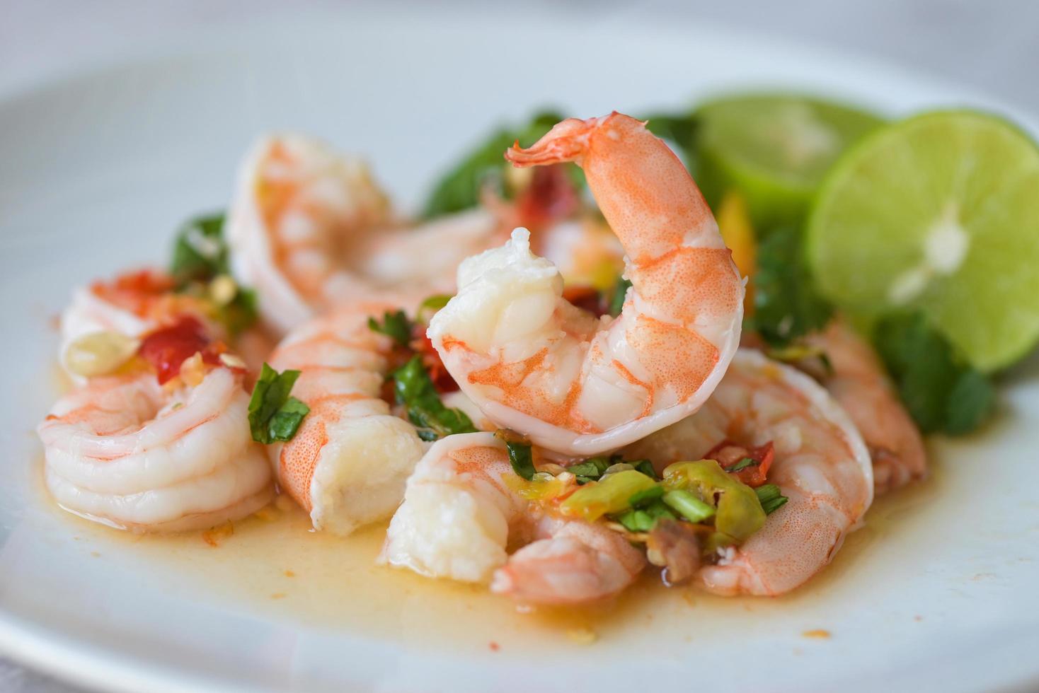 frische Garnelen auf weißem Teller und frischem Gemüse, gekochte Garnelen Garnelen und Meeresfrüchte würzige Chilisauce Koriander, Kochen Garnelensalat Zitrone Limette foto