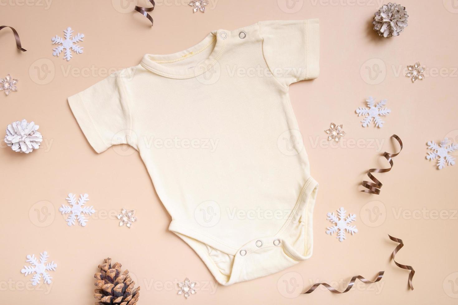 baby babykleidung modell für logo, text oder design auf beigem hintergrund mit winterdekoration draufsicht foto