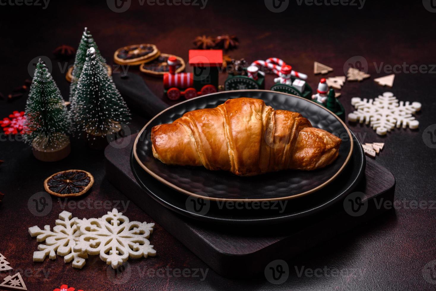 schöne verschiedene weihnachtsdekorationen und croissant auf einem braunen betontisch foto