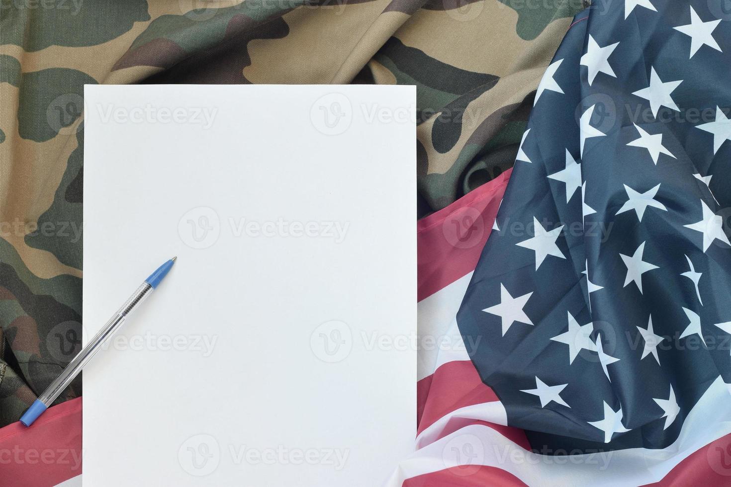 leeres papier liegt auf der flagge der vereinigten staaten von amerika und der gefalteten militäruniformjacke. konzeptionelle hintergrundfahne der militärischen symbole und kopierraum foto