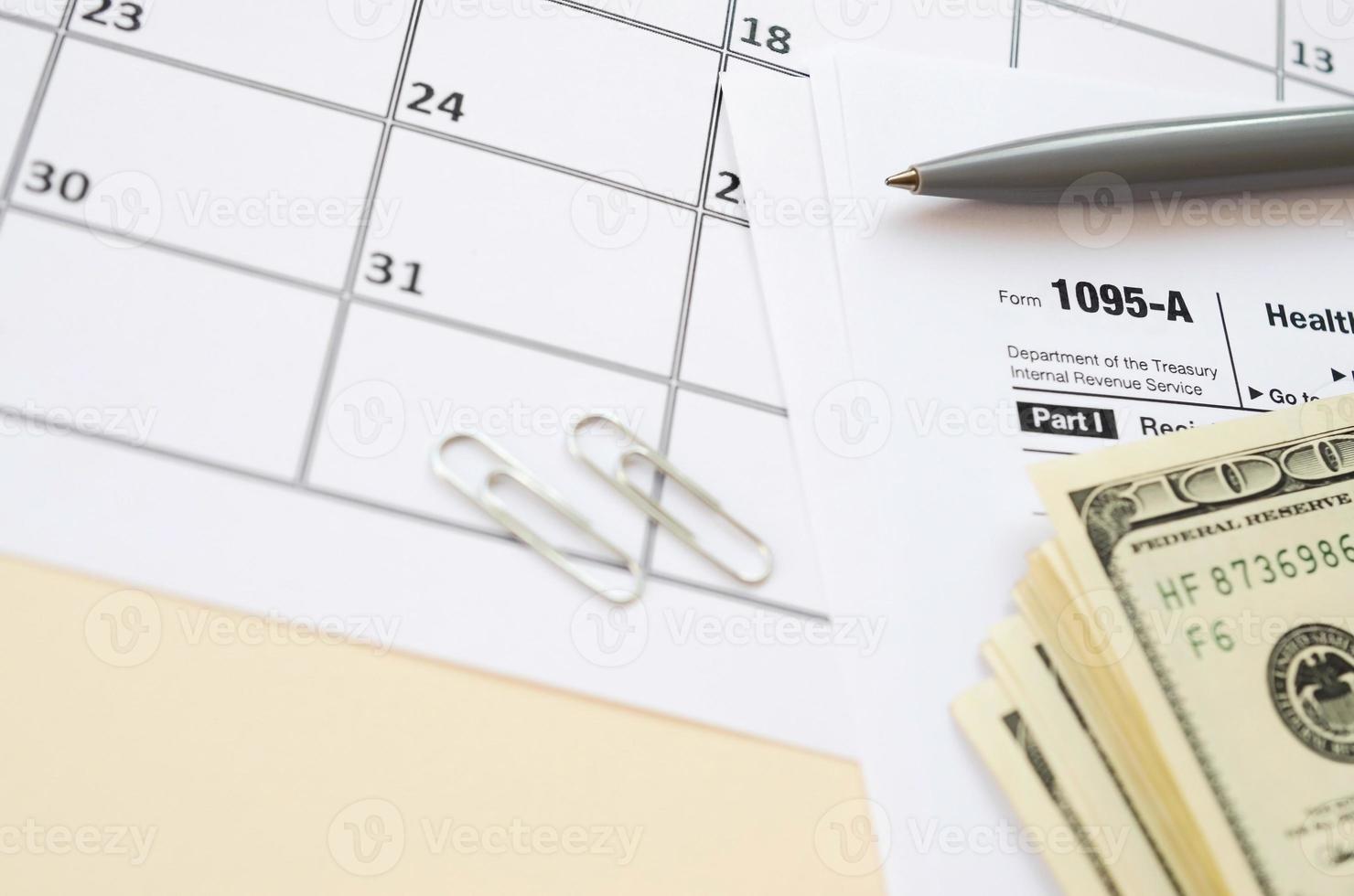 IRS-Formular 1095 – ein Krankenversicherungs-Marktplatz-Auszug Steuerleerzeichen liegt mit Stift und vielen Hundert-Dollar-Scheinen auf Kalenderseite foto