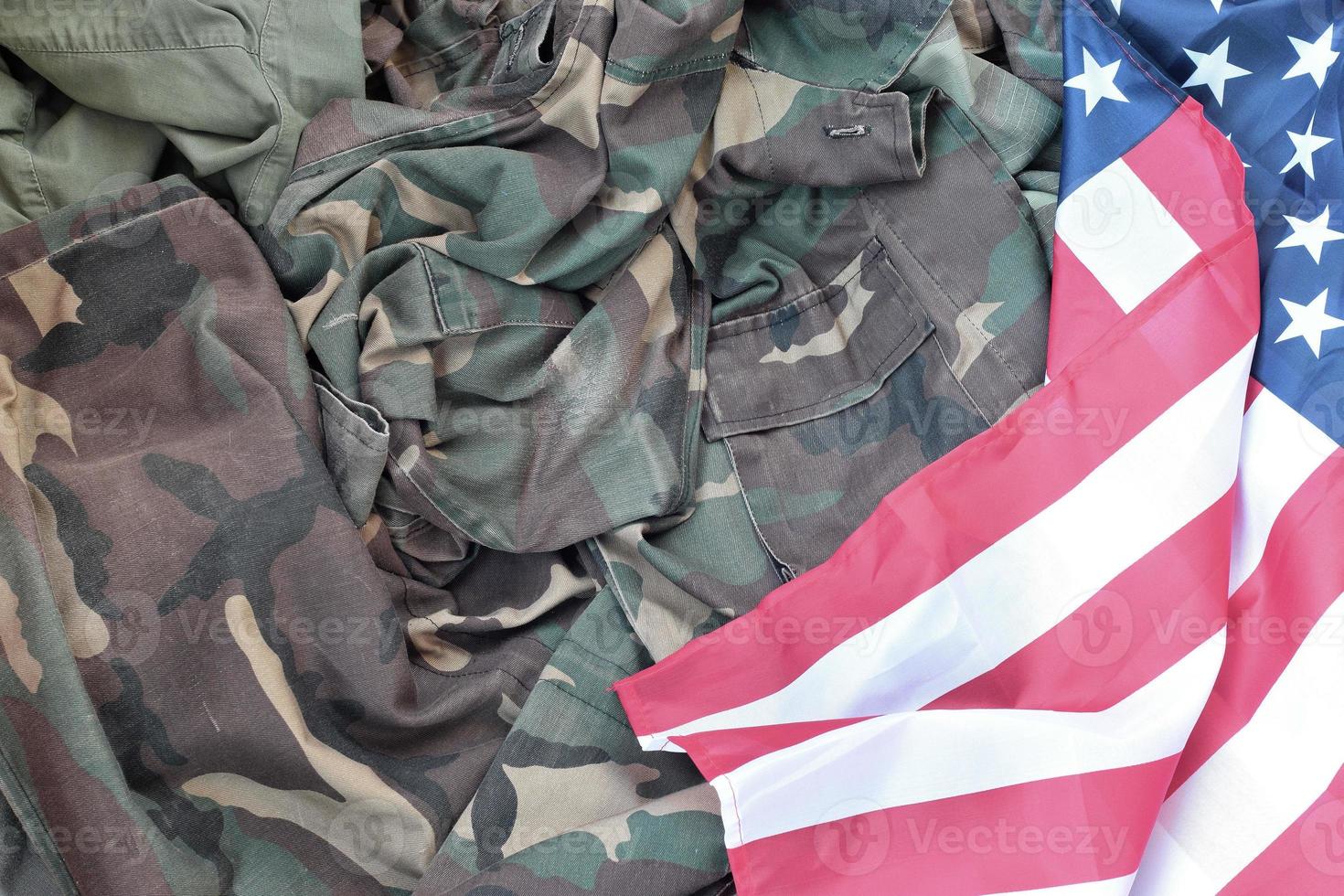 Flagge der Vereinigten Staaten von Amerika und gefaltete Militäruniformjacke. militärische symbole konzeptioneller hintergrundbanner für amerikanische patriotische feiertage foto