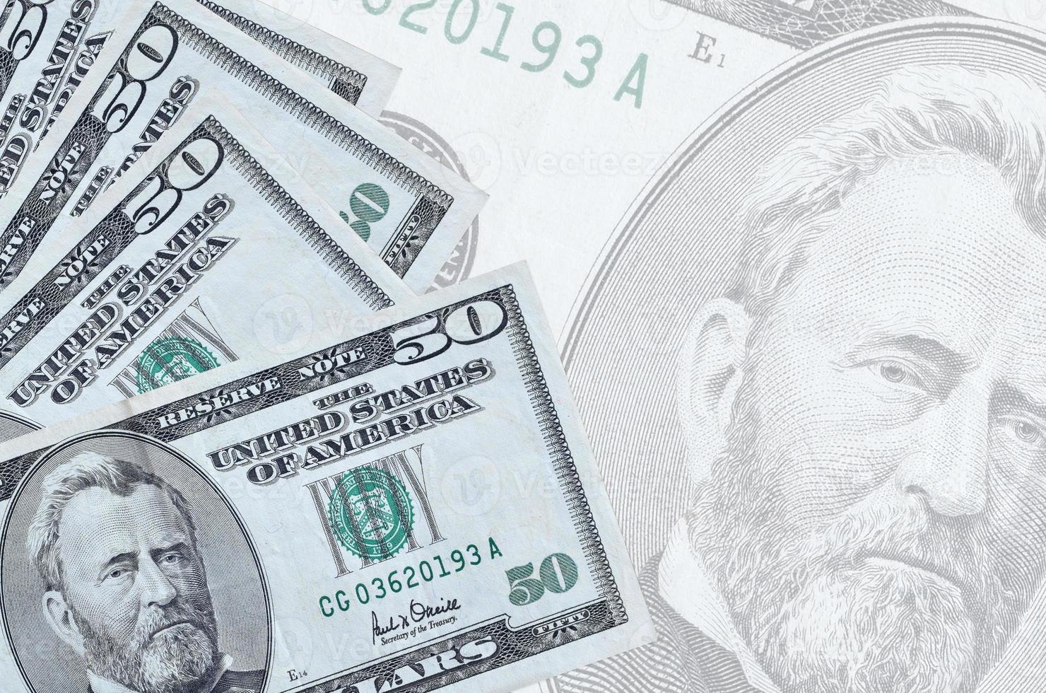 50 US-Dollar-Scheine liegen im Stapel auf dem Hintergrund einer großen halbtransparenten Banknote. abstrakter betriebswirtschaftlicher hintergrund foto